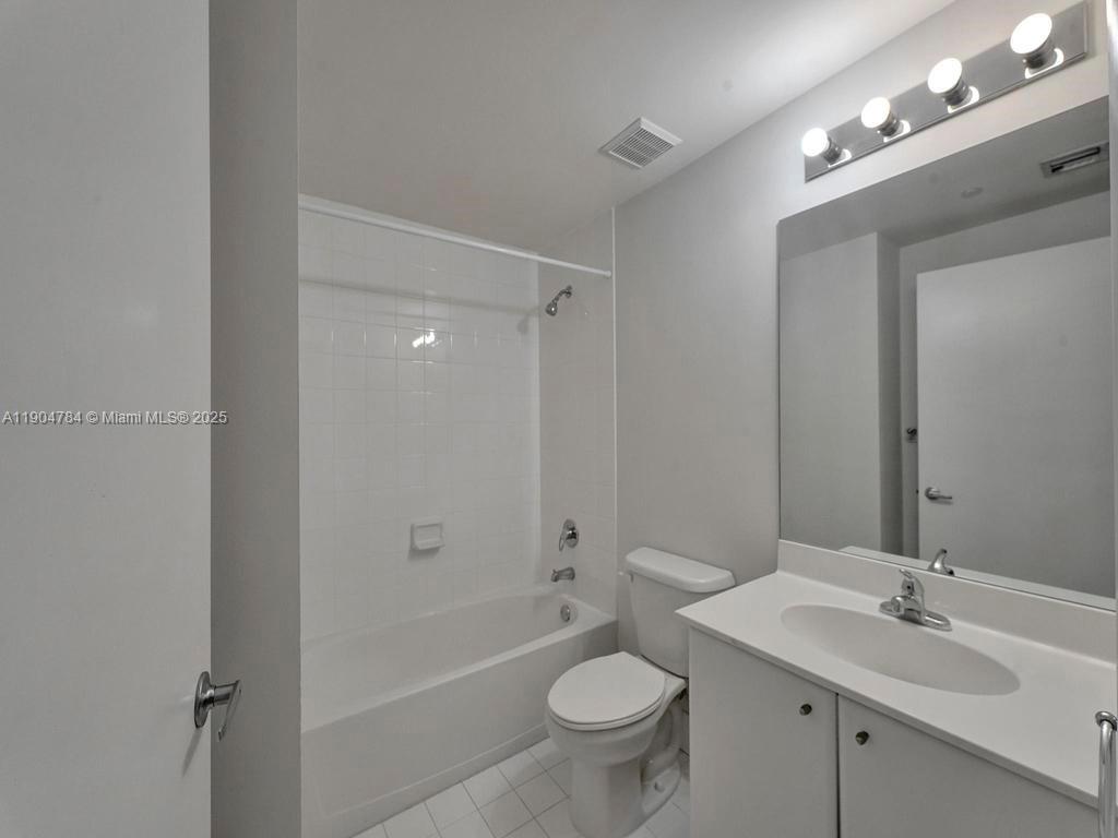 2475 Brickell Avenue, Unit 2006 Miami, FL 33129 - Photo 17 of 61 a bathroom with a double vanity sink toilet mirror and bathtub