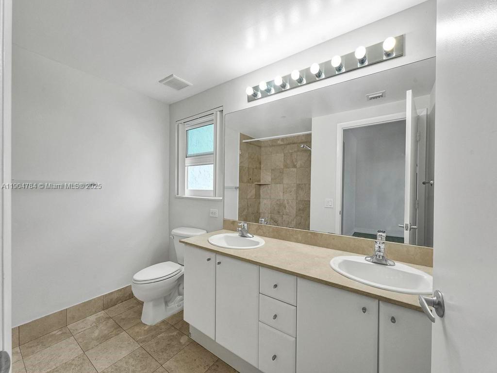 2475 Brickell Avenue, Unit 2006 Miami, FL 33129 - Photo 28 of 61 a bathroom with a double vanity sink a toilet and a mirror