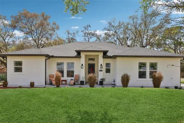 a view of a house with backyard and a tree