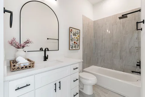 a bathroom with a sink a toilet and a mirror