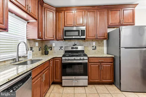 a kitchen with granite countertop a refrigerator stove and microwave