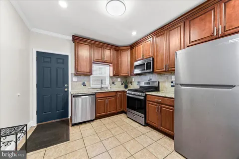 a kitchen with stainless steel appliances granite countertop a refrigerator stove top oven and sink
