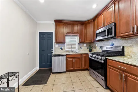 a kitchen with stainless steel appliances granite countertop a stove sink and cabinets