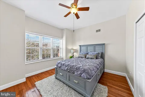 a bedroom with a bed chandelier and a window