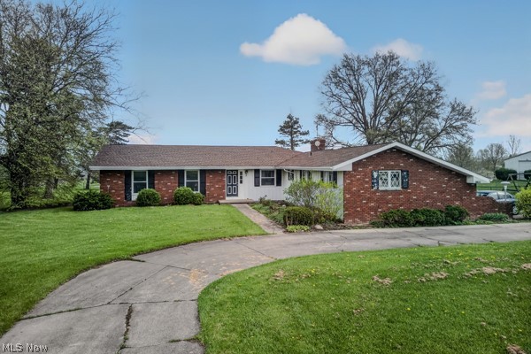 8675 West Smith Road Medina, OH 44256 - Photo 4 of 25 Ranch-style residence featuring a brick and white siding exterior, a dark shingle roof, and a mature treed landscape