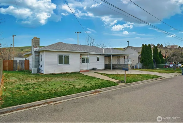 a view of a house with a big yard and large tree