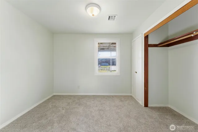 an empty room with windows and closet