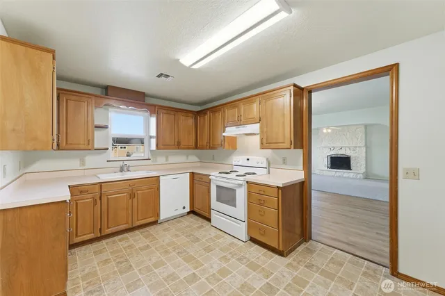 a kitchen with a stove sink and cabinets