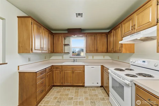 a kitchen with a sink stove top oven and cabinets
