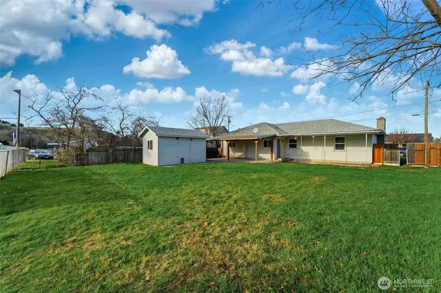 a view of a house with yard and chairs