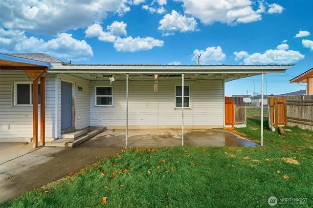 a backyard of a house with table and chairs