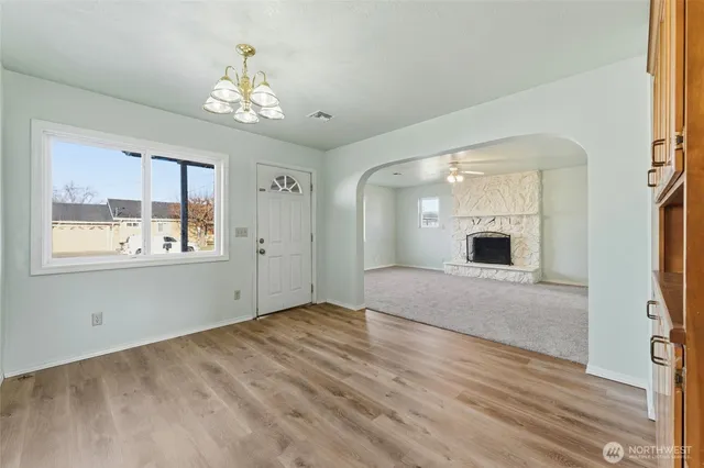 a view of an empty room with window and wooden floor