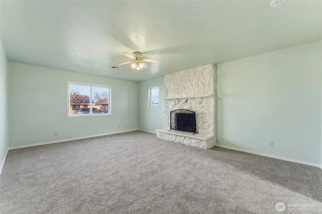 an empty room with a fireplace and chandelier