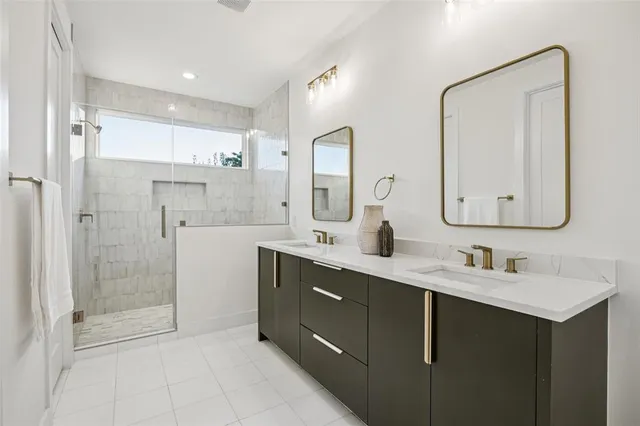 a bathroom with a double vanity sink mirror and shower
