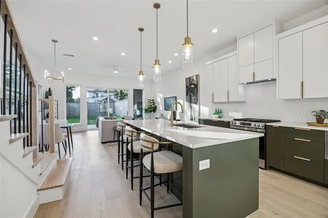a kitchen with stainless steel appliances granite countertop table chairs sink and cabinets