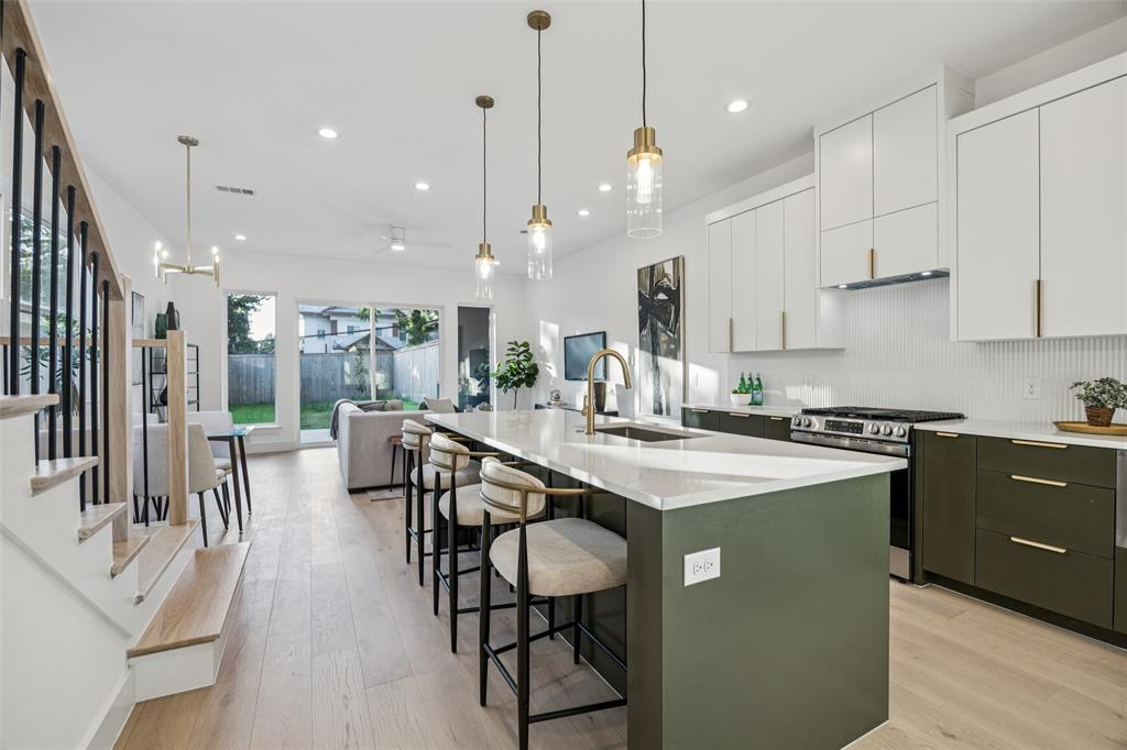 5633 East Side Avenue Dallas, TX 75214 - Photo 3 of 18 a kitchen with stainless steel appliances granite countertop table chairs sink and cabinets