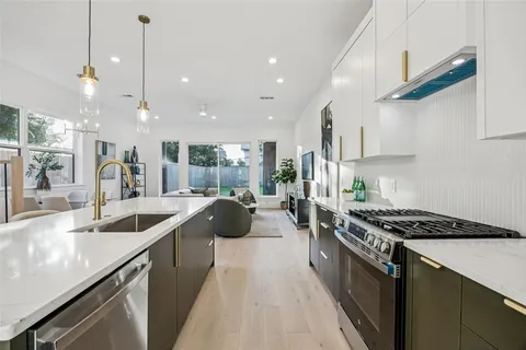 a kitchen with counter top space a sink a stove a refrigerator and blue cabinets