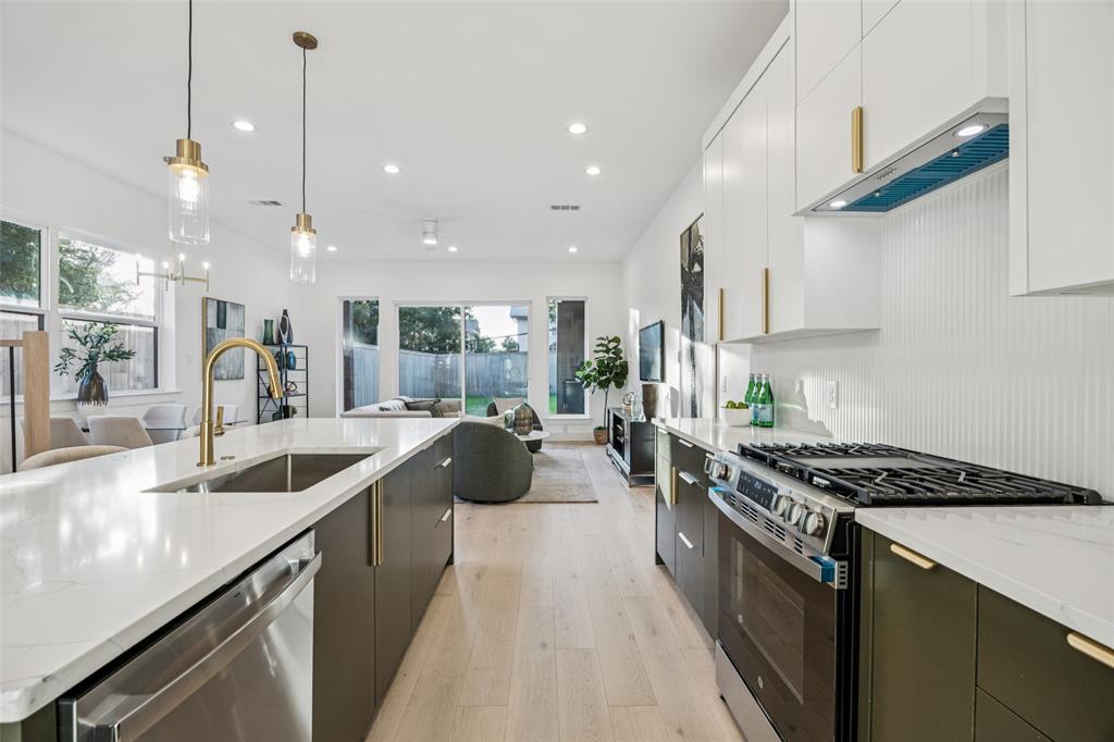 5633 East Side Avenue Dallas, TX 75214 - Photo 4 of 18 a kitchen with counter top space a sink a stove a refrigerator and blue cabinets