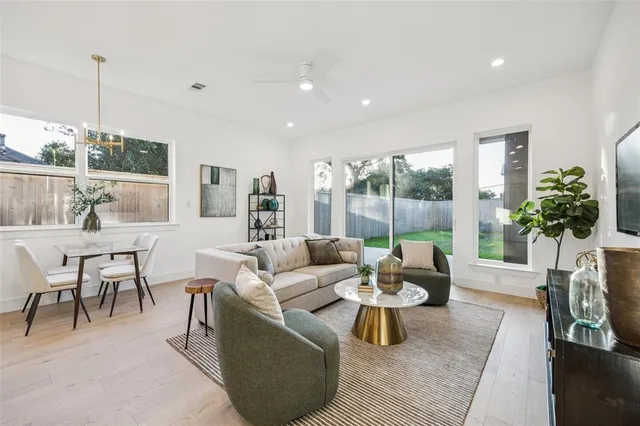 a living room with furniture potted plant and a large window