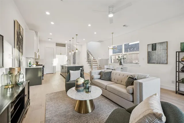 a living room with furniture and a view of kitchen