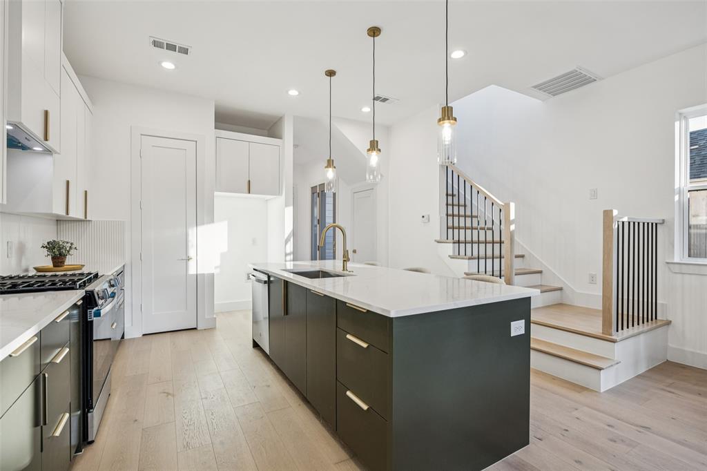 5633 East Side Avenue Dallas, TX 75214 - Photo 8 of 18 a kitchen with granite countertop a sink a counter top space stainless steel appliances and cabinets