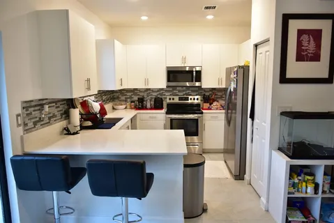 a kitchen with stainless steel appliances a stove a refrigerator and a sink