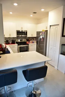 a kitchen with stainless steel appliances kitchen island granite countertop a refrigerator and stove