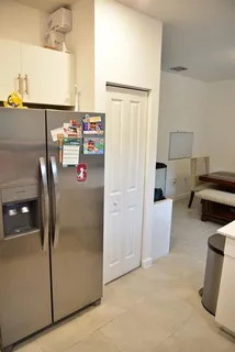 a view of kitchen with furniture and refrigerator