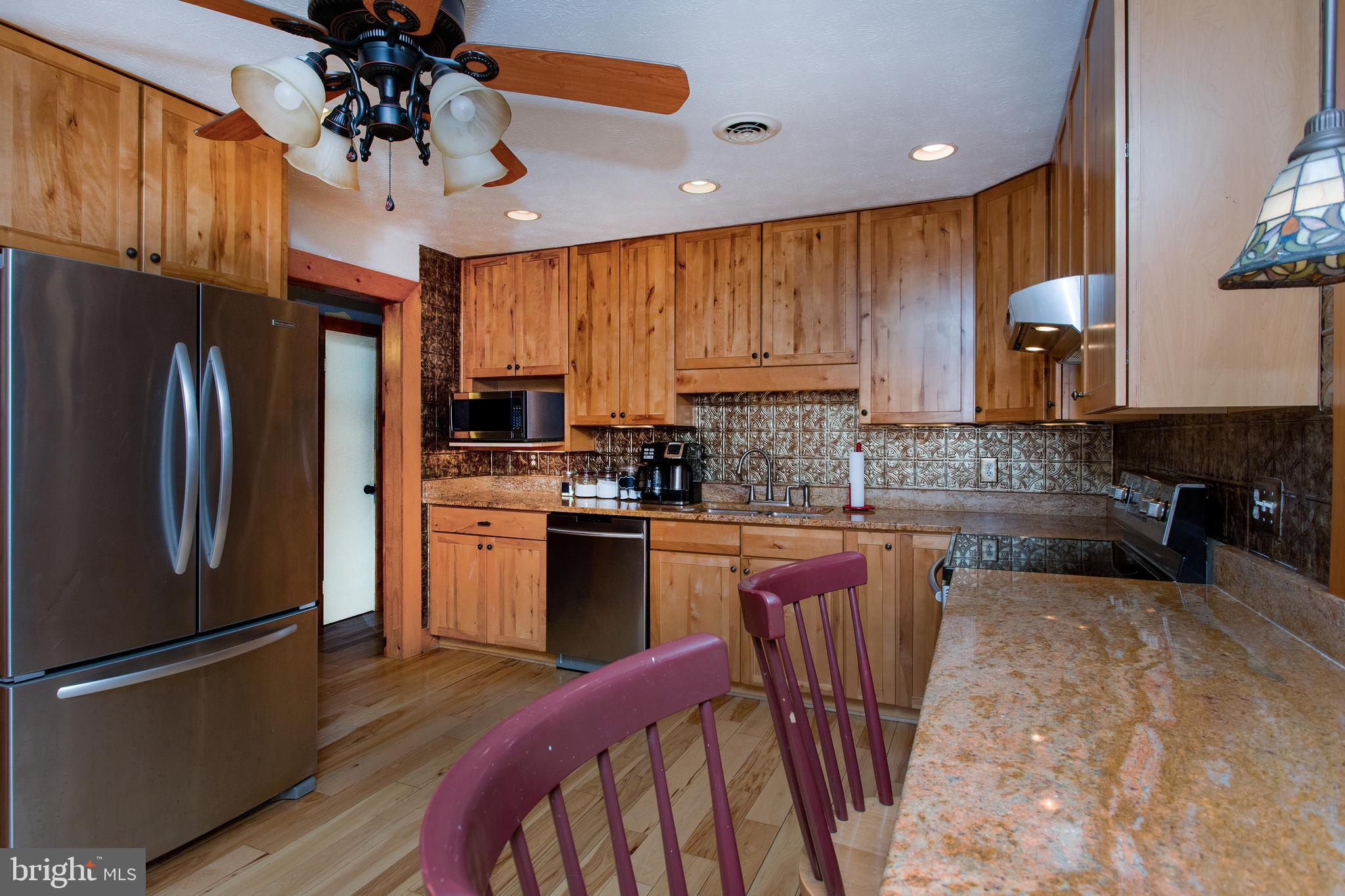 8305 Olivers Shop Road La Plata, MD 20646 - Photo 9 of 43 a kitchen with stainless steel appliances granite countertop a refrigerator a stove top oven a sink dishwasher and wooden cabinets with wooden floor