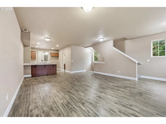 a view of kitchen and a hallway with wooden floor