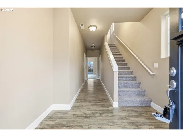 a view of entryway and hall with wooden floor