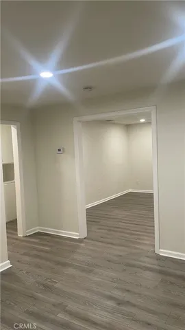 a view of a hallway with wooden floor and closet area
