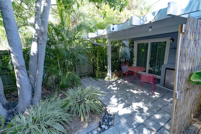 a view of a chair and table in backyard of the house