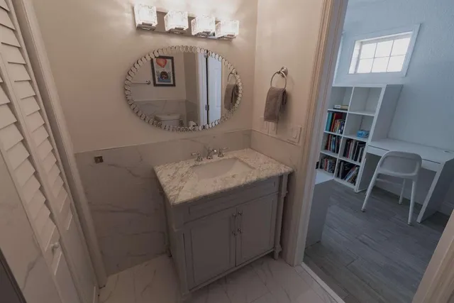 a bathroom with a granite countertop sink and a mirror