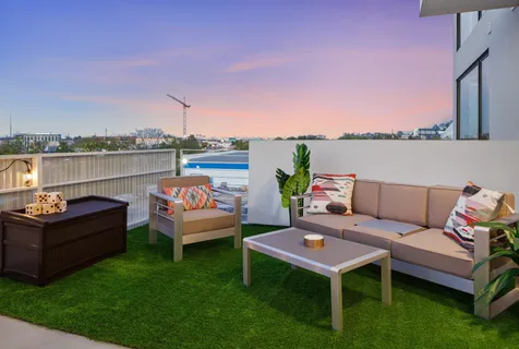 a roof deck with couches and city view