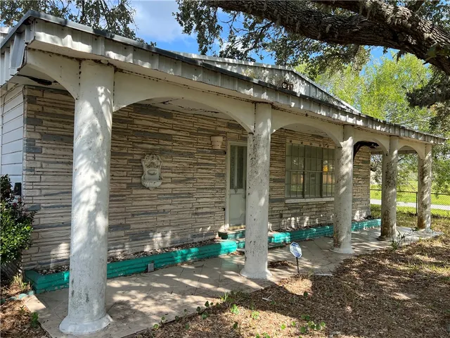 a front view of a house with a tree