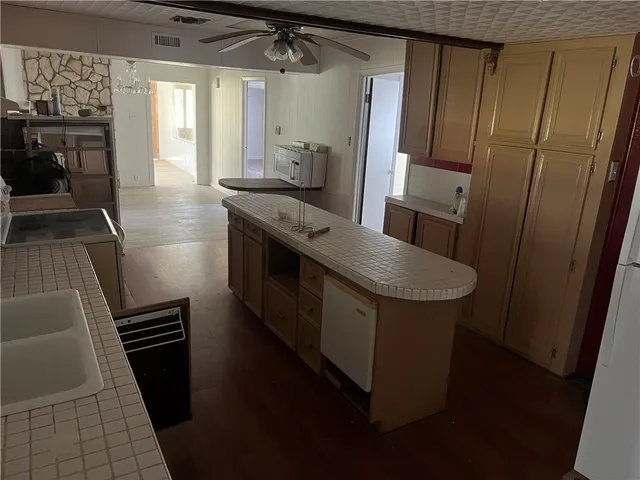 a kitchen with sink a refrigerator and chairs