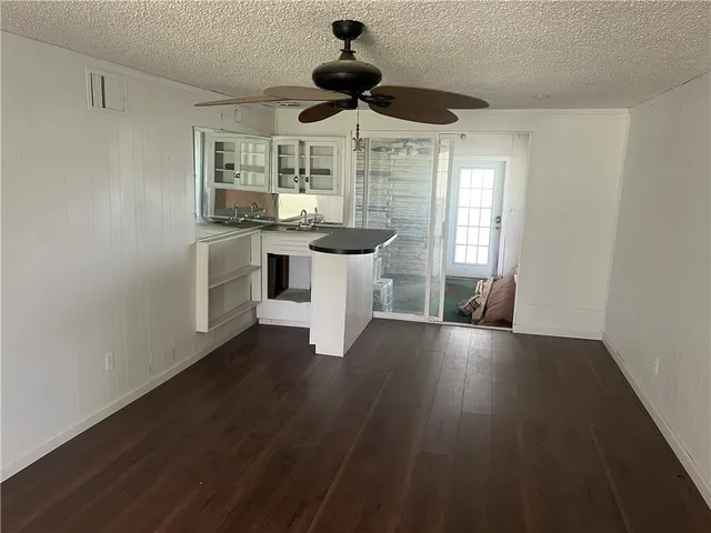a kitchen with stainless steel appliances a dining table chairs and wooden floor