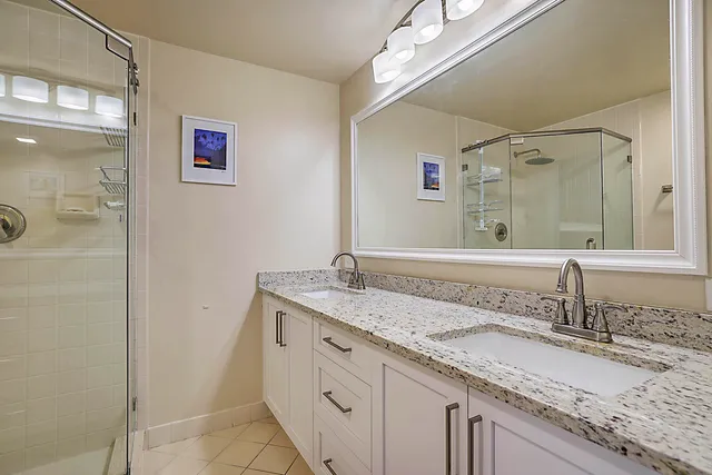 a bathroom with a granite countertop sink and a mirror