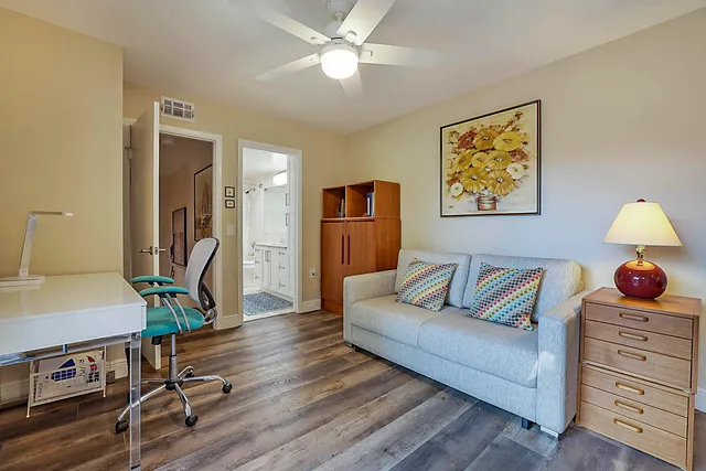 a living room with furniture and a wooden floor