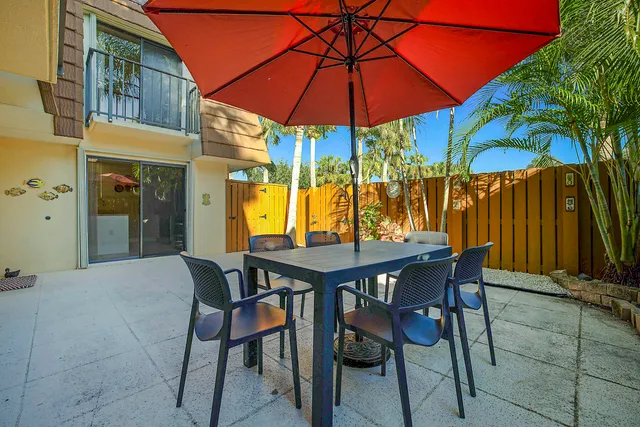 a view of an outdoor space with a table and chairs under an umbrella