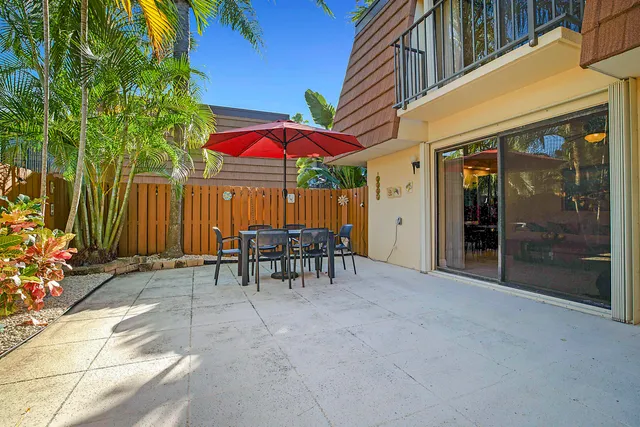 a view of a patio with a table and chairs under an umbrella