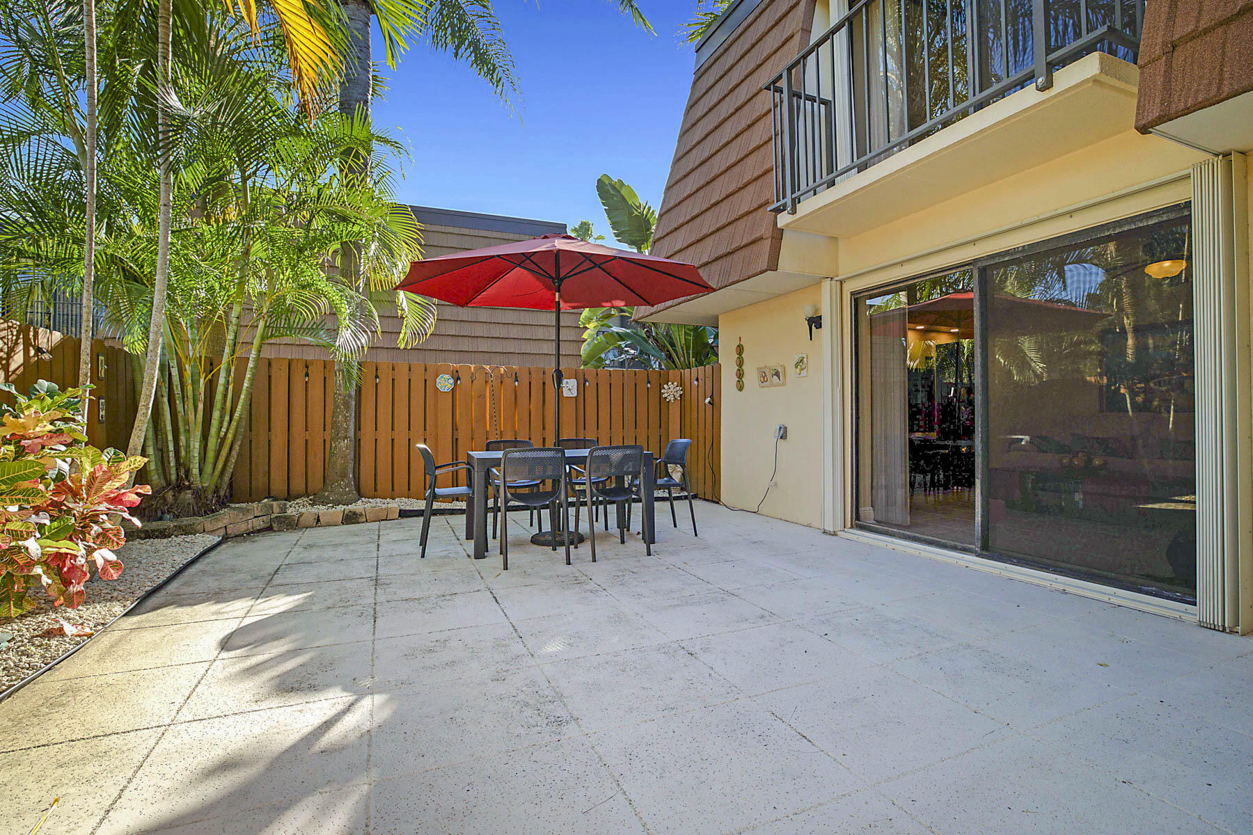 3071 30th Court Jupiter, FL 33477 - Photo 36 of 51 a view of a patio with a table and chairs under an umbrella