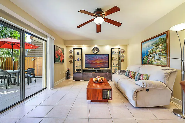 a living room with furniture a floor to ceiling window and a flat screen tv