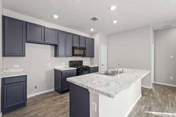 a kitchen with a center island appliances and cabinets