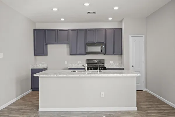 a kitchen with a sink a stove a microwave and cabinets