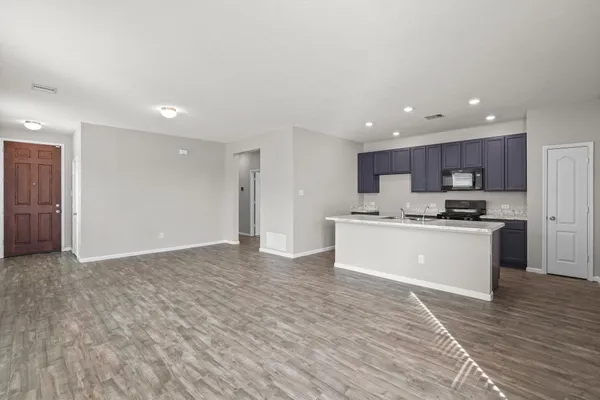 a view of kitchen with granite countertop cabinets and refrigerator