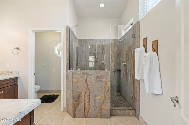 a bathroom with a granite countertop shower a sink and a mirror