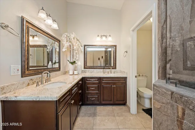 a spacious bathroom with a granite countertop sink and a mirror