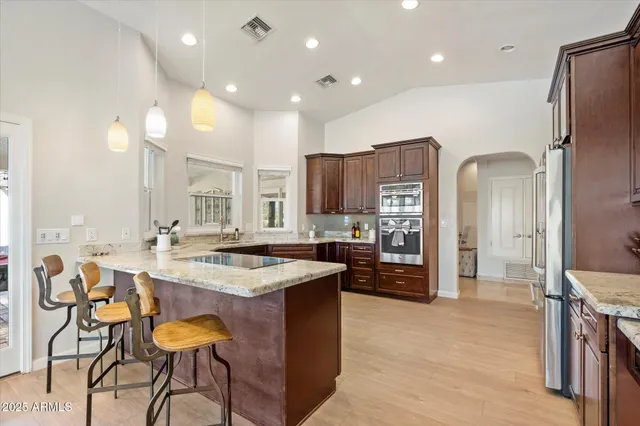 a kitchen with cabinets a counter top space stainless steel appliances and a center island